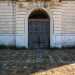 A dominare la facciata  lampio portone in legno iscritto in un arco in pietra ai cui lati sono presenti due finestre entrambe murate
